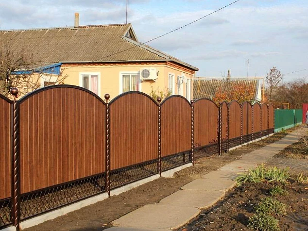 Забор фигурный на ленточном фундаменте из профлиста с ковкой